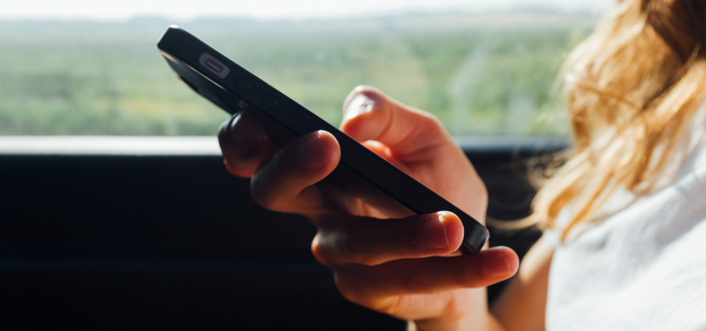 A woman types on her phone