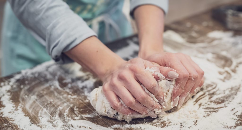 person standing and making dough