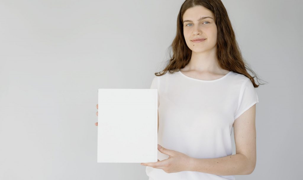 Woman in white shirt holding white blank paper